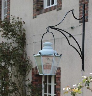 Außenleuchten historisch von Lumart historische Außenleuchten sechseckig an großem Wandarm. Montiert an französischem Chalet.