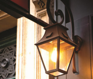 Außenleuchte an der Wand von Roger Pradier Außenleuchte mit Bischons-Wandarm an einem historischen Gebäude. Neben Eingangstür.