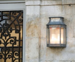 Außenleuchte Louis Philippe Rohzink von Roger Pradier klassische Außenleuchte aus Rohzink. Montiert an einem Schloß Eingang in Frankreich. Die Wandleuchte ist eingeschaltet mit 2 Lichtquellen.