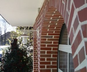 Außenleuchte mit Metallschirm von Surya meditzerrane Außenleuchte an einer Klinker Hauswand angebracht. Metallschoirm mit Jugendstil Wandarm. Weiß. Surya Italien.