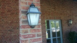 Außenleuchte mediterran Wandlampe von Surya Flache Außenleuchte mediterran an einer Ziegel Hauswand montiert. Flach mit 6 satinierten Lampengläsern. Neben dran ist eine Außenleuchte mit Wandarm im selben Design. Surya.